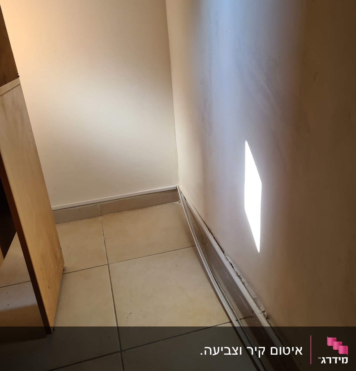 פינה עם קיר מתקלף ופסי חיווט חשופים